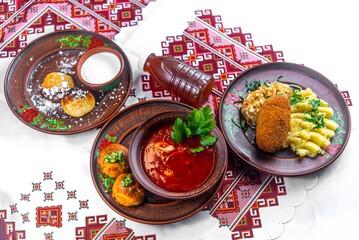 Traditional Ukrainian Cuisine with Borscht, Cutlet Kyiv, Syrnyky, and Varenyky on Embroidered Tablecloth