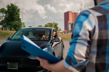 Smiling woman learning to drive and looking out the car window, looking at the instructor with test...