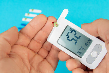 Using a glucometer to check blood glucose levels at home for diabetes monitoring