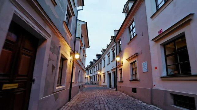 Twilight walk through quaint cobbled alleyway with antique street lamps