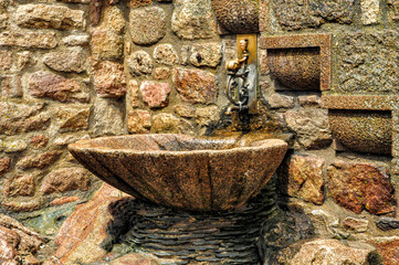 The solitary elegance of an ancient fountain on Mont Saint Michel, France