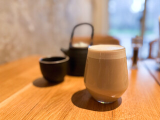 Hot beverage on a wooden table in a cozy cafe interior. Comfort, morning ritual, and peaceful lifestyle through simple objects