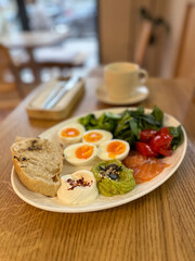 Balanced breakfast with eggs, salmon and vegetables on wooden table. Healthy eating, mindful routine and morning energy boost