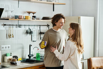 Obraz premium Young couple shares a cozy moment in their modern kitchen while enjoying each others company