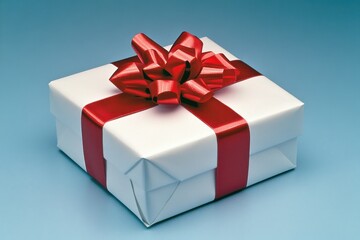 Obraz premium A white gift box with red ribbon and bow on a blue background is ready for giving and celebration