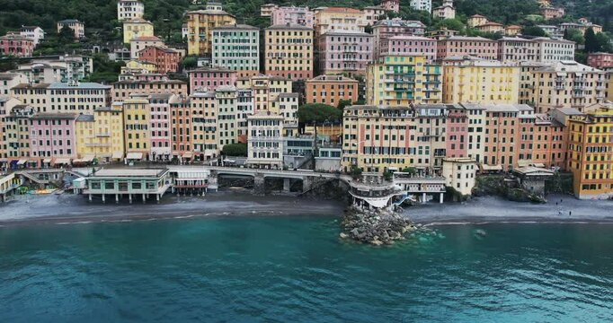 Aerial view of seaside town of Camogli, located in the Liguria region of Italy. It showcases a row of colorful, historic buildings lining the waterfront, creating a vibrant and picturesque view