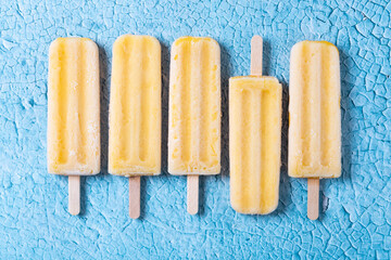 Yellow popsicles on blue background