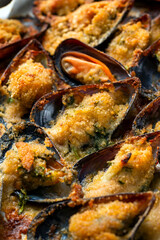 Primo piano di cozze gratinate al forno, ricetta mediterranea, cucina italiana di mare 