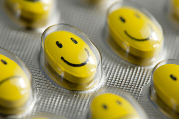 Bright yellow smiley face pills displayed on a blister pack, showcasing unique design and cheerful aesthetic