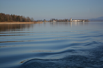 Fraueninsel, Frauenchiemsee on lake Chiemsee in the morning sunrise with boat, Sailboat, church, monastery. Bavaria, Bayern, Germany