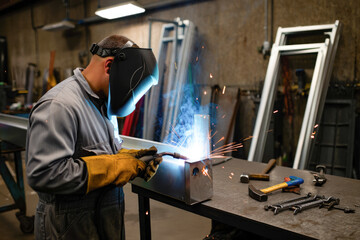 Male welder working with steel in workshop
