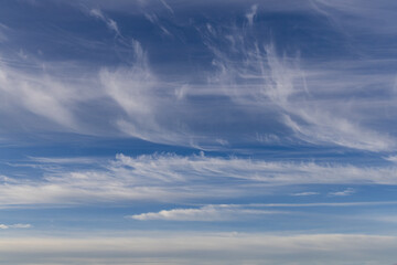 Thin streaky white clouds on the blue sky.