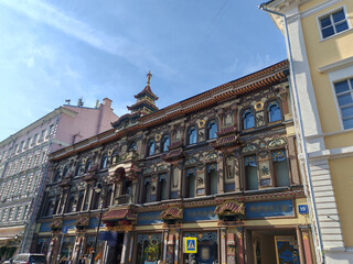 Fototapeta premium tall pink residential building with classical decorative elements, featuring numerous windows and air conditioning units. The facade reflects the charm of historic urban architecture adapted for