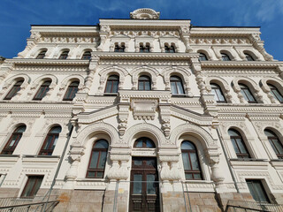 Fototapeta premium A grand neoclassical facade adorned with intricate arches, decorative moldings, and symmetrical windows. The design showcases the sophistication of historic architecture