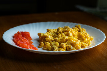 proper breakfast: fried eggs and salmon on a white plate