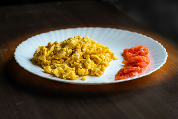 fried eggs and salted salmon on a white plate