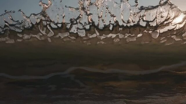 Dramatic ocean waves at sunset reflect golden light in tranquil seascape journey