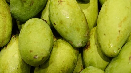 Ripe mangoes as agricultural product in green tones symbol of organic farming and harvest season Green fruit freshness green export commodity for global markets healthy lifestyle and clean eating