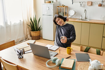 Studying online, a young man engaged in e-learning at home during the afternoon