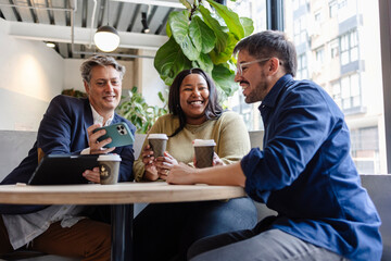 Business people having coffee break and using smartphone in cafe