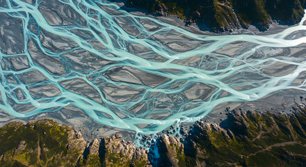 Aerial perspective of a glacial river with braided stream patterns in the mountains