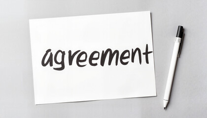 Agreement document on a gray background with a pen  