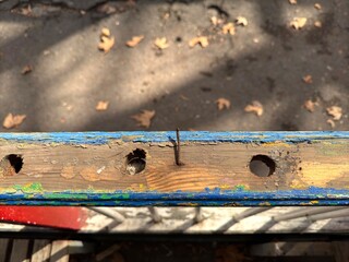 Protruding nails in a blue block on the background of asphalt top view