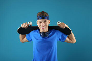 Naklejka premium Happy man with skateboard on light blue background