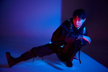 Obraz premium Stylish young man expresses creativity in a vibrant studio with dynamic lighting