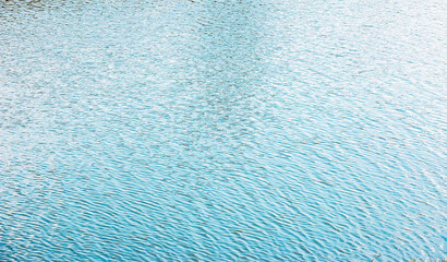 Water surface at sunset, ripples of river with small waves, calm and close-up. Natural background. Abstract texture.