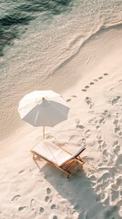Beach chair and umbrella on white sand with ocean waves