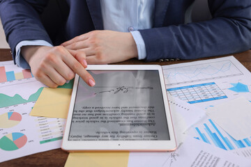 Electronic signature. Woman using tablet at table, closeup