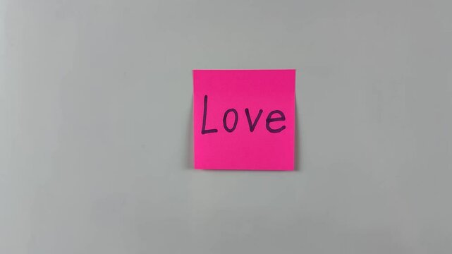 Sticky note with word Love written on it, pinned on white background. Symbolizes affection, connection, and care. Ideal for emotional and relationship concepts