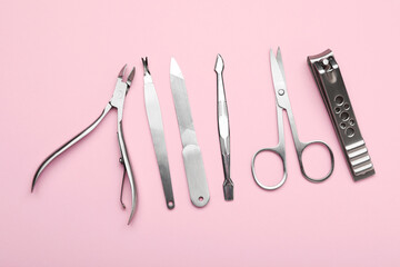 Set of different manicure tools on pink background, flat lay