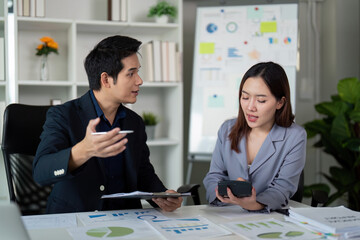Strategic Planning and Analysis. Colleagues engaging in a discussion over financial graphics and data.