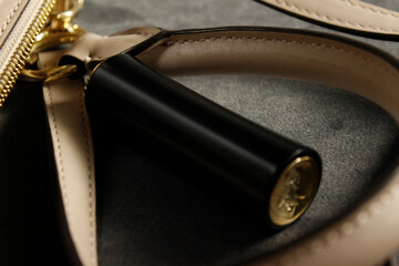 a black tube of women's lipstick on the background of accessories. close-up.