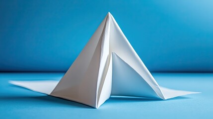 A large triangle folded from white paper . 