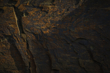 A natural stone texture background with chiaroscuro lighting, featuring a monolithic rock...