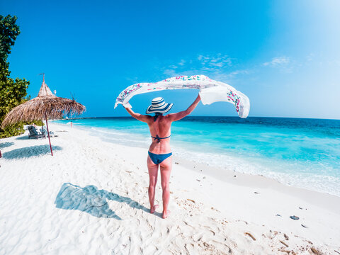 Beautiful woman relaxing on a tropical beach, The Maldives, Indian Ocean