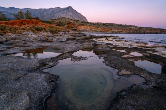 Aspes beach, natural holes in the rocks full of water at sunset, with sea in the background