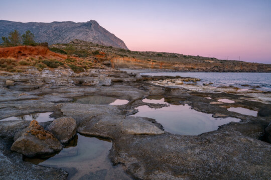 Aspes beach, natural holes in the rocks full of water at sunset, with sea in the background