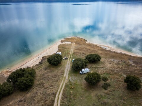 Drone aerial view of camper vans parked on a wild spot at Lake Polyfyto, Kozani, Macedonia