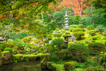 Picturesque view of mossy mounds, stone accents, and tranquil pond in Shuheki-en Garden near Sanzen-in Temple, Kyoto, Honshu