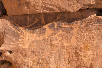 Ancient symbols and rock carvings on a sandstone rock cliff in the Sharaan Nature Reserve, AlUla, Medina Province