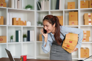 Entrepreneurship and Communication. A businesswoman talking on the phone while handling packages.