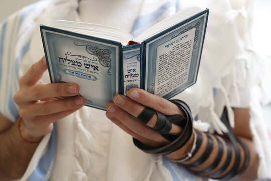 Celebration of Purim festival, faithful holding book and wearing phylacteries, Beth Loubavitch Synagogue, Montrouge