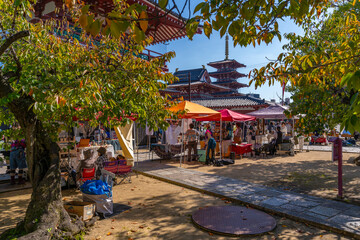 View of market stalls and Shitenno-ji Gojunoto (Five Story Pagoda) on a sunny day, Shitennoji, Tennoji Ward, Osaka, Honshu