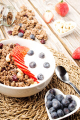 Muesli with organic berries and nuts. Oat muesli with raspberry, blueberry, strawberries, almond, cashew, banana. Healthy food, top view