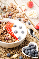 Muesli with organic berries and nuts. Oat muesli with raspberry, blueberry, strawberries, almond, cashew, banana. Healthy food, top view