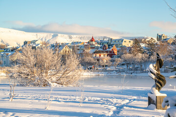 View of Tjornin park, town and mountains on a sunny day in winter, Reykjavik